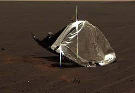 یک جسم فلزی گرد و له شده در سطح مریخ.